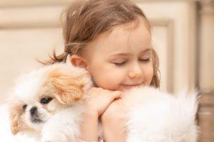 Child hugs new puppy